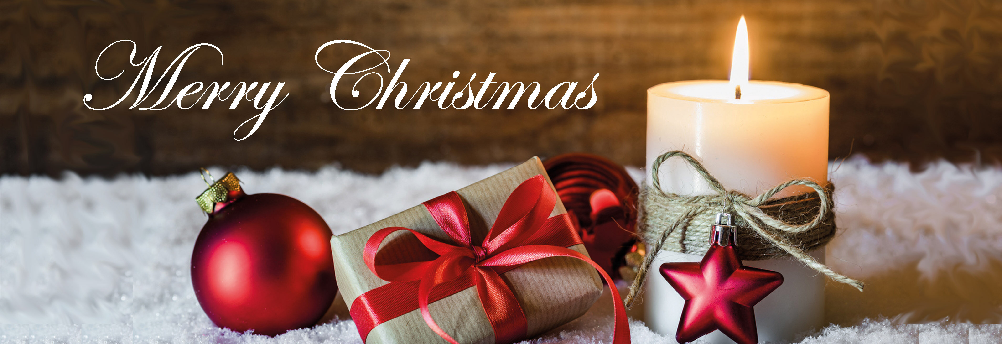 Stimmungsvolles, weihnachtliches Stillleben mit brennender Kerze, roten Weihnachtskugeln und kleinem Geschenk | © Richard Tscherwitschke GmbH